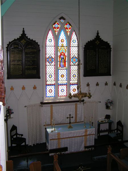 A view of the Altar displaying the stain glass window in memory of John Slade.